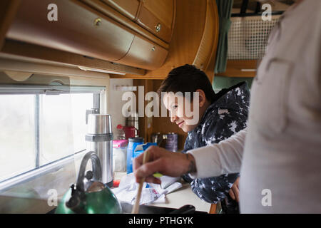 Vater und bald Kochen und Blick aus Fenster in Motor home Stockfoto