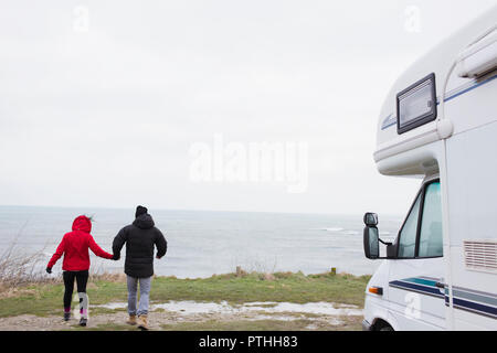 Paar Hände halten außerhalb Motor home mit Blick auf den Ozean Stockfoto