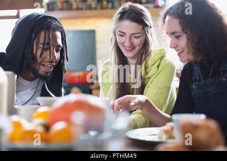 Jungen Mitbewohner Freunde mit digitalen Tablet am Frühstückstisch Stockfoto