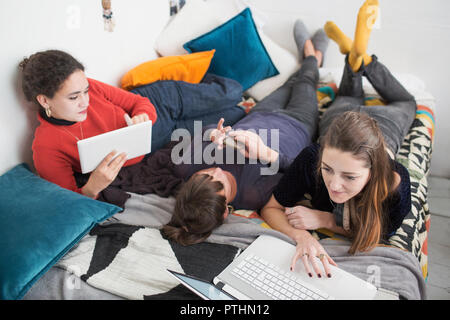 Junge Frauen student Mitbewohner studieren auf dem Bett Stockfoto