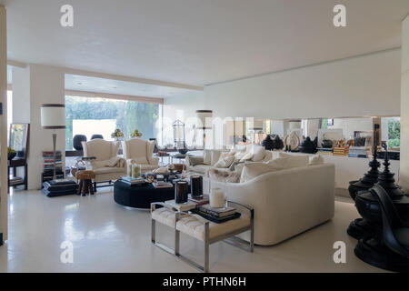 Interieur mit einem eleganten Wohnzimmer mit Blick auf einen privaten Garten in einem Haus in Italien Stockfoto
