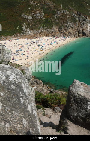 Porthcurno Strand, in der Nähe von Porthcurno, West Cornwall. Spektakuläre urlaub Strand mit kristallklarem Meer entfernt. Stockfoto