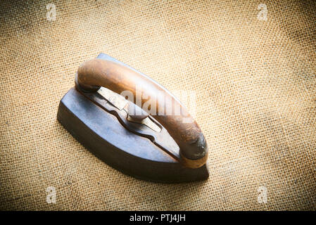 Nahaufnahme von Vintage alte rostige Bügeleisen auf sack Tuch. Selektiver Fokus Stockfoto