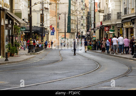 Hüdavendigar Straße mit Straßenbahn Linien entlang laufen, wie Leute auf dem Bürgersteig neben, Istanbul, Türkei Fuß Stockfoto