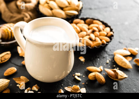 Hausgemachte Mandelmilch in der Kanne. Mandelmilch und Mandeln Stockfoto