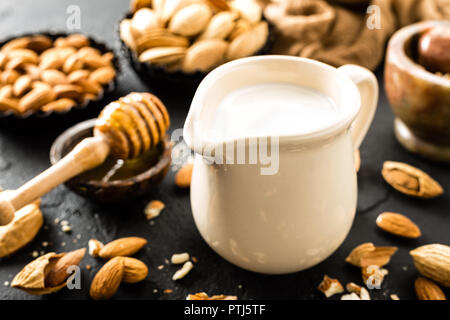 Hausgemachte Mandelmilch in der Kanne. Mandelmilch und Mandeln Stockfoto
