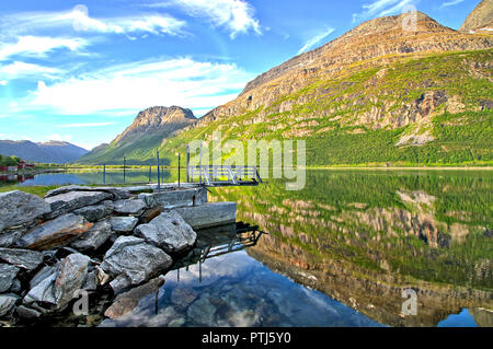 Eine Bootsanlegestelle am Meer am Morgen. Die bunten Berge von Wasser reflektierende Oberfläche. Stockfoto