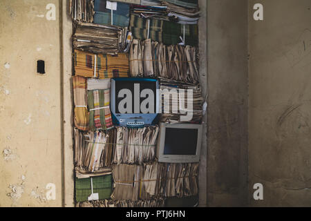 Stapel der alten Zeitschriften, Zeitungen und zwei Computer Monitore an der Wand. "Made by ... Feito por Brasileiros" zeitgenössische Kunst installation, Sao Paulo Stockfoto