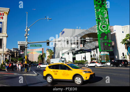 Gelbes taxi Zusammenführen am Las Vegas Boulevard (Strip), Las Vegas, Nevada. Passagierflugzeug, sichtbar in den Himmel.. Stockfoto