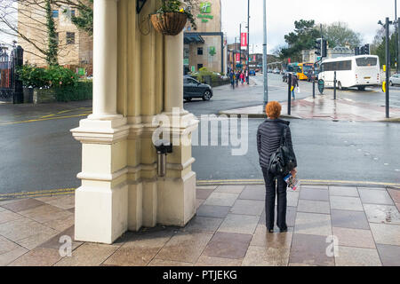 Eine Frau, die unter dem Portikus der Engel Hotel im Stadtzentrum von Cardiff in Wales. Stockfoto