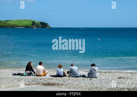 Urlauber entspannen auf dem privaten Strand Polgwidden Cove at Trebah Garten in Cornwall. Stockfoto