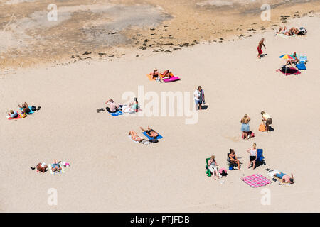 Urlauber entspannen und sonnenbaden auf Tolcarne Beach in Newquay in Cornwall. Stockfoto