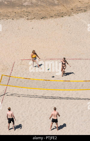 Junge Leute, beim Beachvolleyball am Tolcarne Beach in Newquay in Cornwall. Stockfoto