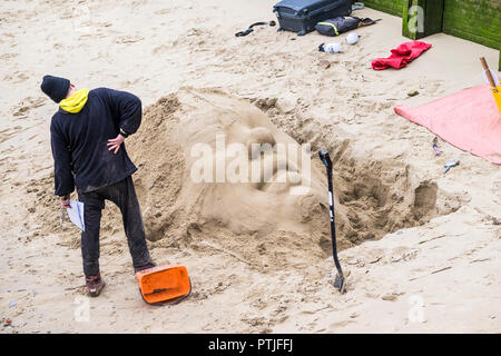 Ein Bildhauer eine Sand Skulptur am Ufer der Themse an der South Bank in London. Stockfoto