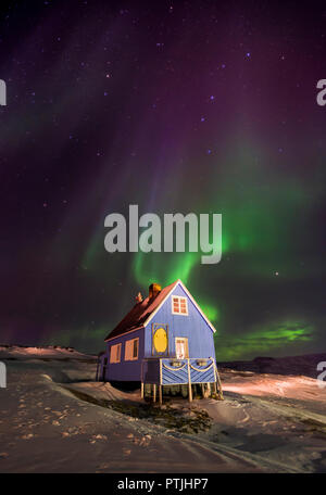 Die Nordlichter über Oqaatsut Dorf im Westen von Grönland. Stockfoto