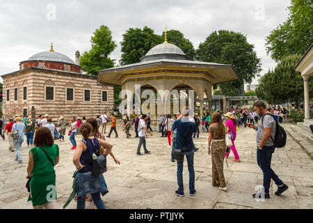 Die Waschung Brunnen außerhalb der Hagia Sophia Museum als Touristen vorbei an einem Frühlingstag, Istanbul, Türkei Stockfoto