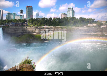 Niagara Falls, USA - 29. August 2018: Schöne Aussicht auf die Niagara Fälle mit Regenbogen der kanadischen Seite mit berühmten Hotels gegenüber der amerikanischen Seite, Stockfoto