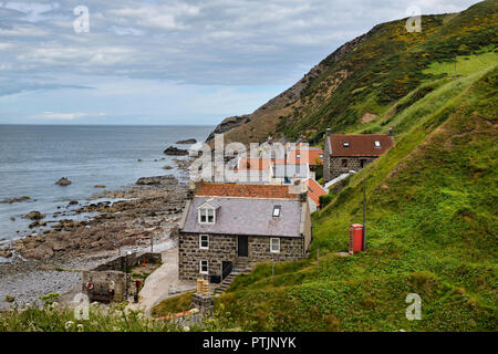 Einzelne Zeile von Häusern der Crovie Küstenfischerei Dorf auf Gamrie Bucht Nordsee Aberdeenshire Schottland Großbritannien mit roten Telefonzelle Stockfoto