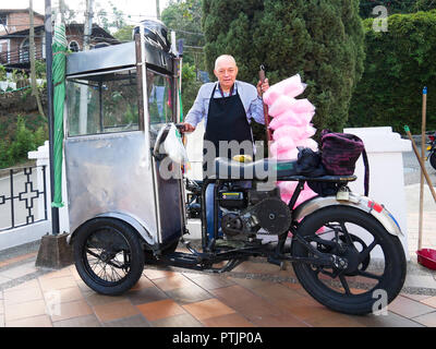 Ein alter Mann verkauf von Zuckerwatte Zuckerwatte im Atrium der katholischen Kirche mit seinen maßgeschneiderten Fahrzeug Stockfoto