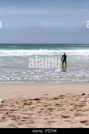 Ein Surfer geht aus dem Meer Stockfoto