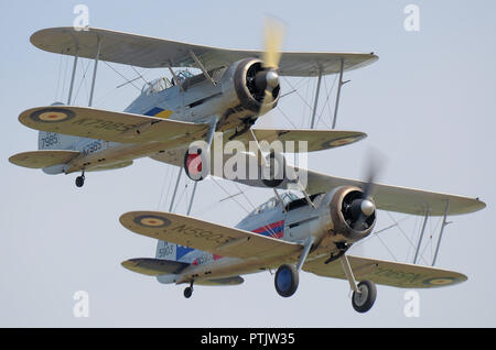 Zwei Gloster Gladiator-Doppeldecker fliegen auf einer Flugschau. RAF, Royal Air Force 1930, Jagdflugzeug zu Beginn des Zweiten Weltkriegs im Dienst Stockfoto