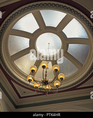 Ein Kronleuchter hängen unter einem Oberlicht in Victoria Hall, Saltaire, Bradford, Yorkshire Stockfoto