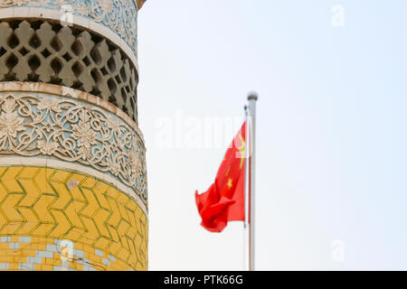 Uigher Eidgah Moschee Minarett mit Chinesischen Flagge in der Alten Stadt Kashgar, oder Kashi, Xinjiang, China. Stockfoto