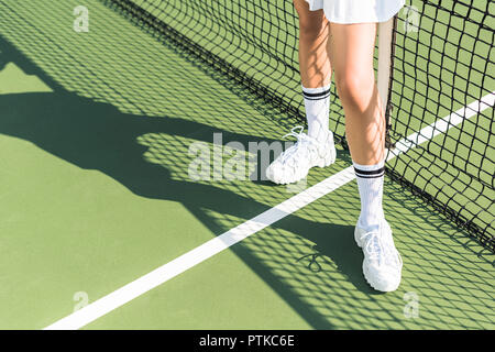 Teilweise mit Blick auf die weibliche Tennisspieler in der Nähe von Tennis Netz auf dem Hof Stockfoto