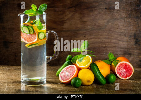 Sassy Wasser mit Zitrone, Grapefruit, Orange, Minze, Gurke und Ingwer, selektiver Fokus, auf hölzernen Hintergrund Stockfoto