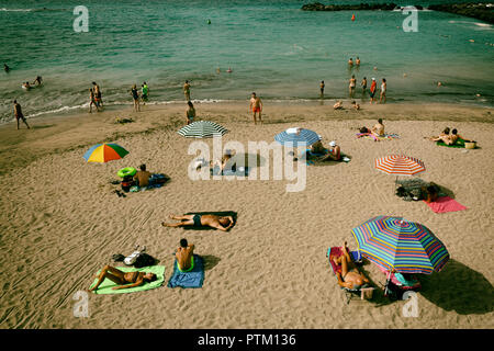 Urlauber genießen Sie ein Sonnenbad am Strand, Torviscas, Playa El Duque, Costa Adeje, Teneriffa, Kanarische Inseln, Spanien Stockfoto