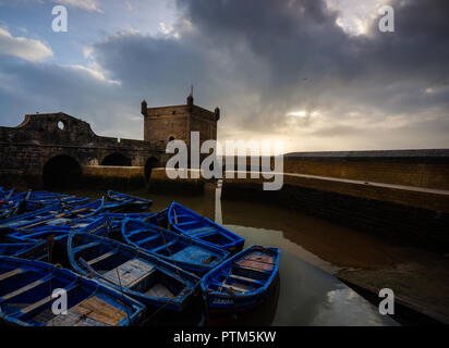 ESSAOUIRA, MAROKKO - ca. Mai 2018: Sonnenuntergang über dem Hafen von Essaouria und die berühmten Castelo Real von Mogador. Stockfoto