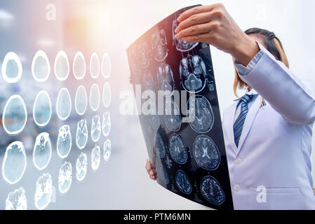 Frau Doktor holding MRI Film zur Diagnose von Verletzungen des Gehirns mit Double Exposure von Gehirn-CT-Scan Stockfoto