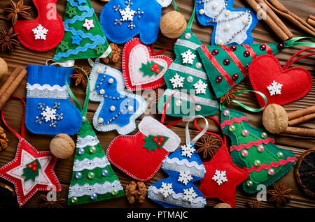 Verschiedene handgefertigte rustikalen fühlte Christbaumschmuck mit Anis, Zimt und Walnüssen auf hölzernen Tisch Stockfoto