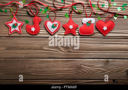Handgefertigte rustikalen rotem Filz Christbaumschmuck liegend auf hölzernen Tisch Stockfoto