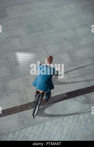 Rückansicht der Geschäftsmann in formalen Verschleiß Reiten Fahrrad auf der Straße Stockfoto