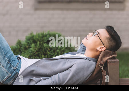 Stilvolle asiatischer Mann schlafen auf der Werkbank Stockfoto