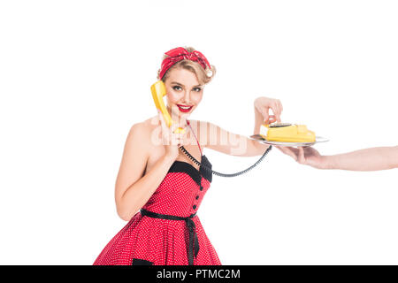 Junge Pin up Frau wählen die Telefonnummer der retro Telefon auf serviertablett in männlicher Hand isoliert auf weiss Stockfoto