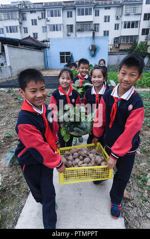 Huzhou, der chinesischen Provinz Zhejiang. 10 Okt, 2018. Die Studierenden führen ausgewählte Gemüse in die schulkantine an Donglin Volksschule in Donglin Stadt Huzhou Stadt, der ostchinesischen Provinz Zhejiang, Okt. 10, 2018. Die Plantage von Donglin Grundschule in der erntezeit vor kurzem. Credit: Xu Yu/Xinhua/Alamy leben Nachrichten Stockfoto