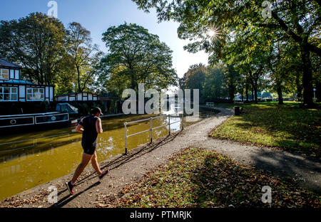 Worsley, Manchester. 10.Oktober 2018. UK Wetter: herrlich warmen Herbst Sonnenschein grüßt morgen Wanderer in Worsley, Manchester als mini Indian Summer im Nordwesten Englands schlägt. Ein Jogger läuft entlang der Treidelpfad der Bridgewater Canal. Bild von Paul Heyes, Mittwoch, den 10. Oktober 2018. Credit: Paul Heyes/Alamy leben Nachrichten Stockfoto