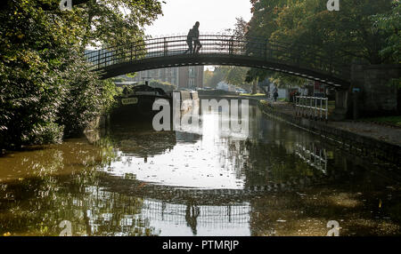 Worsley, Manchester. 10.Oktober 2018. UK Wetter: herrlich warmen Herbst Sonnenschein grüßt morgen Wanderer in Worsley, Manchester als mini Indian Summer im Nordwesten Englands schlägt. Ein paar Gehminuten über die Fußgängerbrücke auf der Bridgewater Canal. Bild von Paul Heyes, Mittwoch, den 10. Oktober 2018. Credit: Paul Heyes/Alamy leben Nachrichten Stockfoto