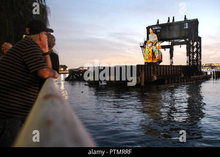 New York, USA. 09 Okt, 2018. Besucher beachten Sie die Art der Installation des New Yorker Künstlers Tony Oursler auf einem ehemaligen Kran Brücke von einem weggeworfenen Pier projiziert. Unter anderem historische Figuren oder das Wappen der Stadt New York gesehen werden kann. Die Installation wird bis zum 31. Oktober geplant. (Dpa' Künstler Projekte video Kunst auf New York Pier' vom 10.10.2018) Credit: Christina Horsten/dpa/Alamy leben Nachrichten Stockfoto