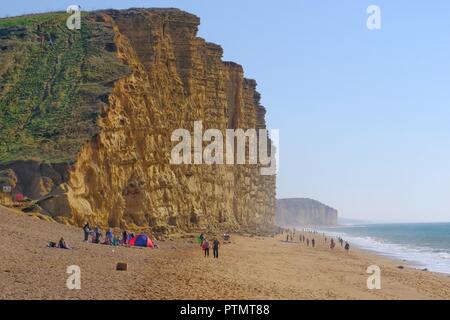 West Bay, Dorset, Großbritannien. 10 Okt, 2018. Besucher nach West Bay genießen Sie die anhaltende warme Wetter. Trotz schlechtem Wetter Warnungen die Temperatur an der Küste von Dorset bleibt wärmer als normal Credit: Tom Corban/Alamy leben Nachrichten Stockfoto