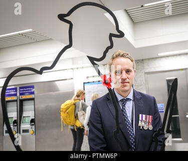 Victoria Station, London, 10. Okt 2018. Liebe Direktor Rowley Gregg, einem ehemaligen britischen Offizier in der Armee, in der Victoria Station mit der Tommy Statue. Chelsea Rentner sammeln Spenden in zwölf Londoner U-Bahn-Stationen, heute im Namen der Nächstenliebe "erinnert". Eröffnungs-Projekt der Nächstenliebe", es aber nicht Es' hat das Ziel, zum Gedenken an jene, die in der WK 1 starb, die Jungen zu erziehen und die heutigen Veteranen leiden von der mentalen und körperlichen Wunden der Service während der Hundertjahrfeier 2018 heilen. Credit: Imageplotter Nachrichten und Sport/Alamy leben Nachrichten Stockfoto