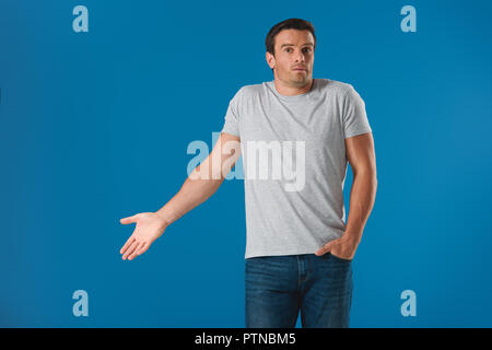 Mann und deutete mit der Hand und die Kamera isoliert auf Blau überrascht Stockfoto