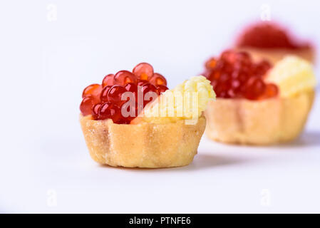 Mehrere Törtchen mit rotem Kaviar und Butter auf weißen Ba isoliert Stockfoto