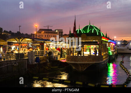 Die schwebende Küchen Eminonu Basar leuchtet in der Dämmerung mit Menschen im Essbereich sitzt, Istanbul, Türkei Stockfoto