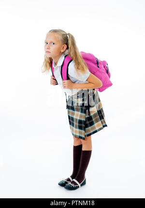 Süßes kleines Mädchen in Uniform tragen von schweren Big Pink Rucksack oder Schule Tasche voll verursacht Stress und Schmerzen auf der Rückseite durch Übergewicht isoliert auf weißem b Stockfoto