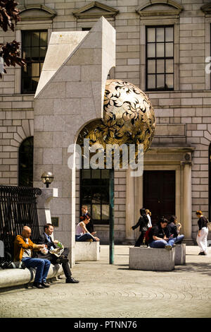 Die Leute, die das Mittagessen auf Zentralbank Plaza, Dublin. Skulptur ist eine Crann Óir (Baum aus Gold) von Éamonn O'Doherty (1939-2011) Stockfoto