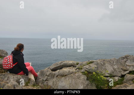 Schöne Frau sieht die Unendlichkeit des Kantabrischen Meer von oben Gulpiyuri Beach im Rat von Llanes. Natur, Reisen, Landschaften, Beac Stockfoto