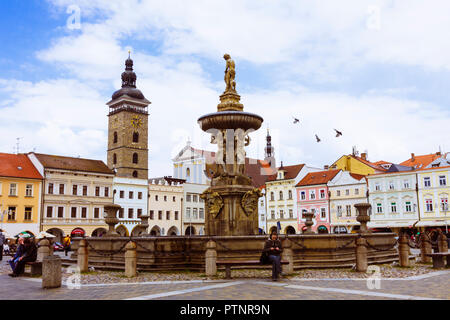 Ceske Budejovice, Südböhmen, Tschechische Republik: Menschen rund um die simson Brunnen sitzen an der großen Ottokar II Square. Schwarzer Turm im Hintergrund. Stockfoto